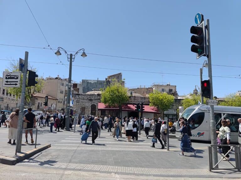 עוברים ושבים חוצים את הכביש ליד תחנת כיכר ציון בירושלים, יום אחרי חג העצמאות 2025