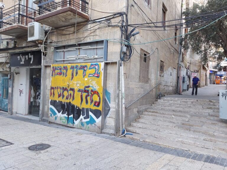 גרפיטי צבעוני על דלת סגורה במרכז ירושלים, סמוך למדרגות אבן