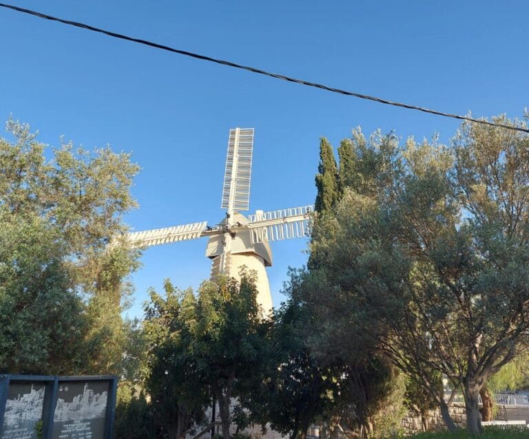 תחנת הרוח מונטיפיורי בירושלים, מוקפת עצים תחת שמיים כחולים