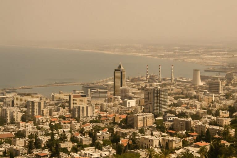 נוף פנורמי של מפרץ חיפה ביום אביך, תחת שמיים מאובקים