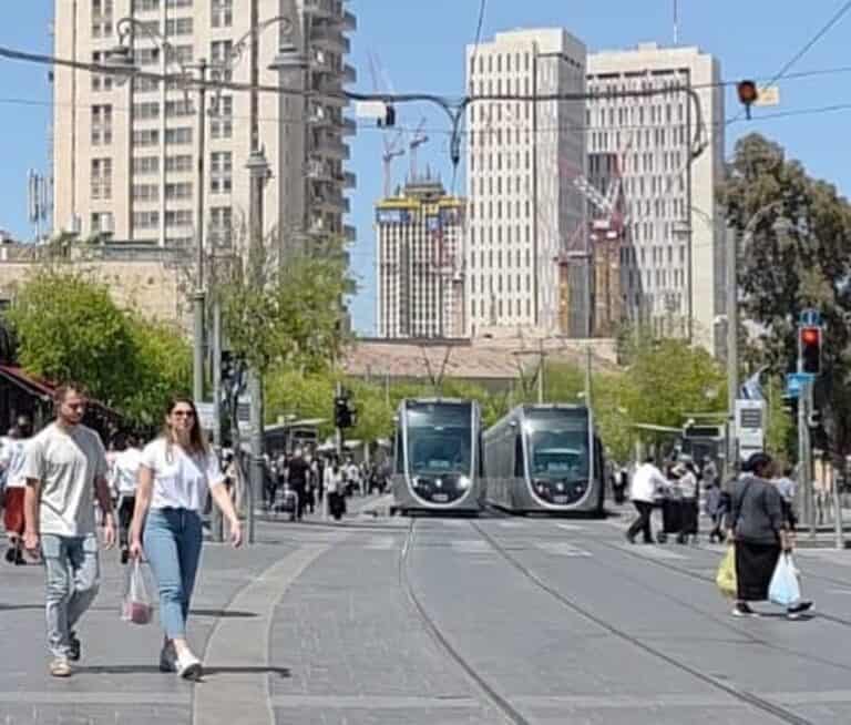 רכבת קלה ברחוב יפו בירושלים עם הולכי רגל, רקע של מגדלים