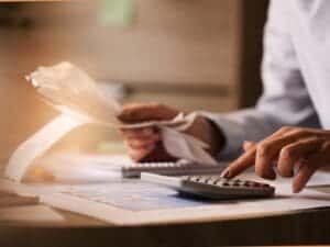 אדם מחשב הוצאות עם חשבוניות ומחשבון – המחשה לניהול כספי בהפועל ירושלים