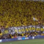 Beitar Jerusalem fans in yellow cheering during the 2025 State Cup final at Bloomfield Stadium