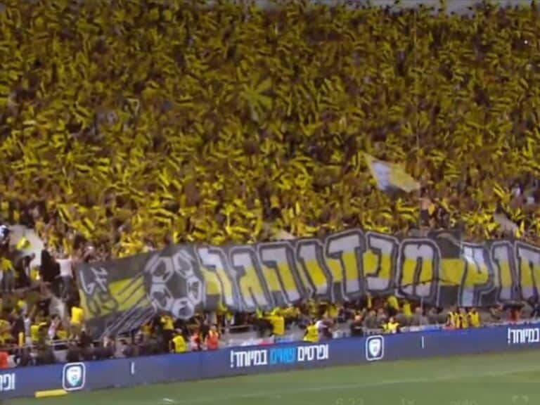 Beitar Jerusalem fans in yellow cheering during the 2025 State Cup final at Bloomfield Stadium