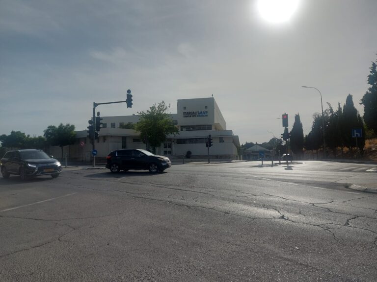 כביש ירושלמי שקט בשעות הבוקר עם אור שמש רך ותחושת המתנה באוויר