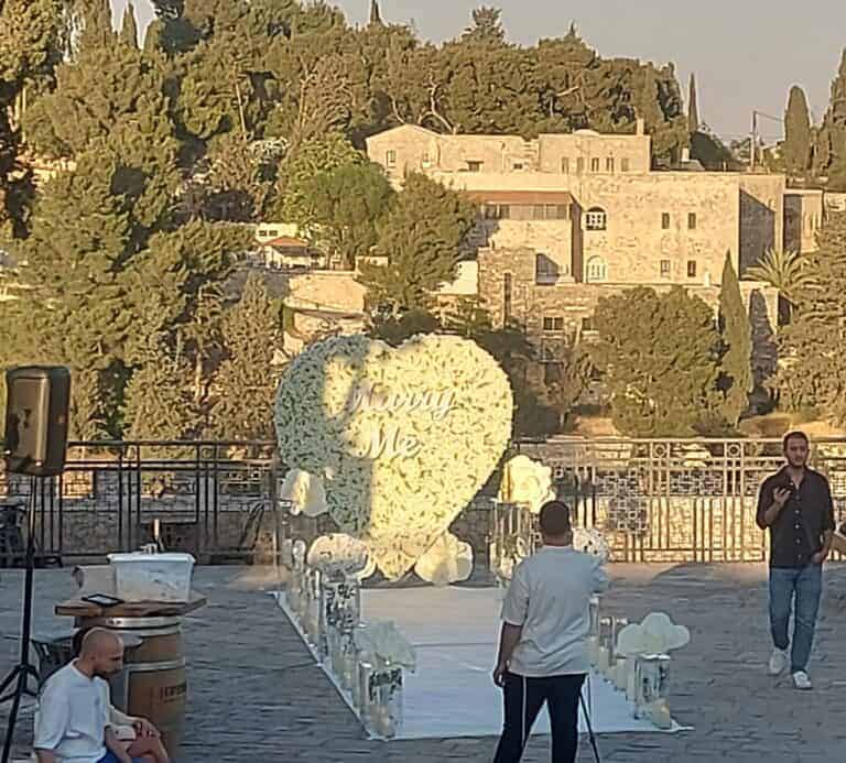 לב פרחים ענק מוצב ברחבה ירושלמית פתוחה במשכנות שאננים, לקראת הצעת נישואין באור שקיעה