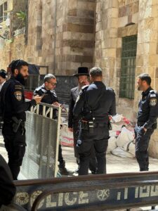 אנשי משטרה וגבר דתי, ככל הנראה רב, בסמוך לכותל הקטן בירושלים, במהלך עבודות השיפוץ באתר הרגיש