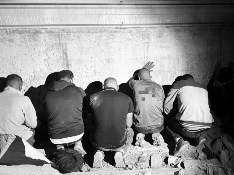 Suspected illegal infiltrators detained under a bridge in Jerusalem during nighttime police operation