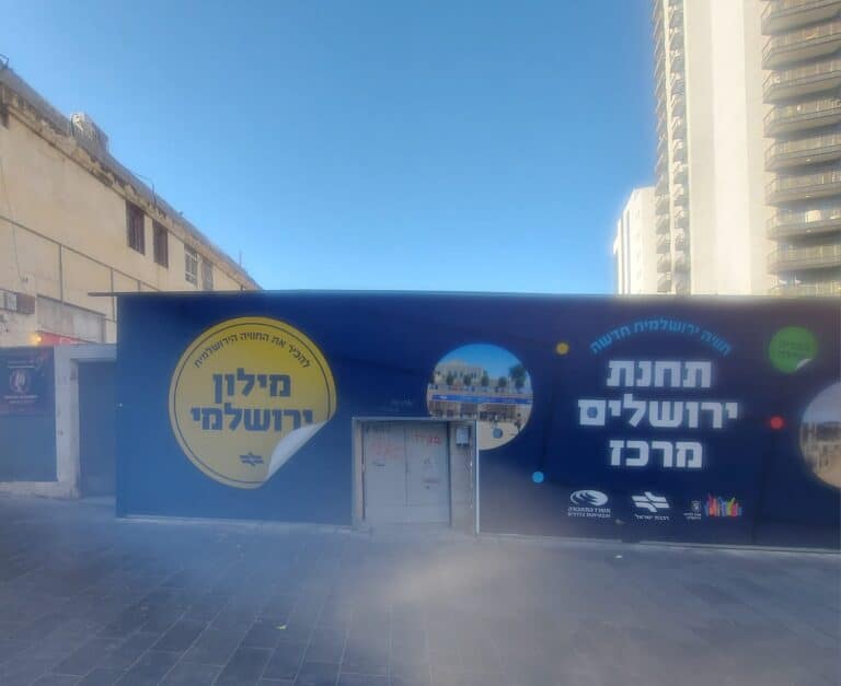 A bright summer day in central Jerusalem near the future Jerusalem Central Station, with clear skies and Pride Week events underway