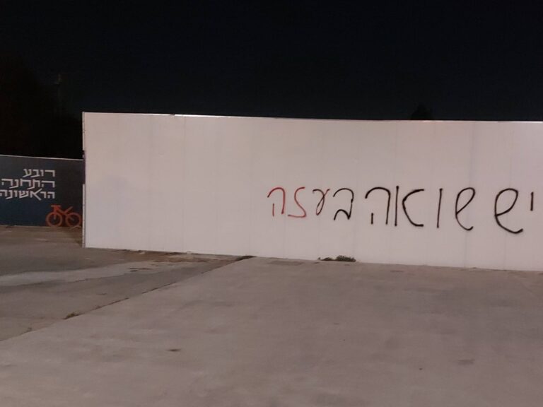 Graffiti at Jerusalem’s First Station reads “There is a Holocaust in Gaza,” painted in bold black and red