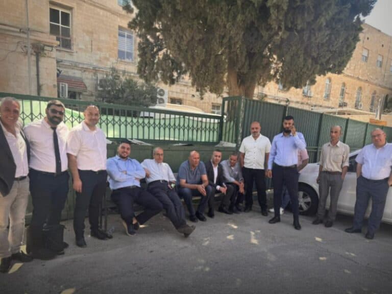 Group of Palestinian lawyers sitting and standing near Jerusalem police station after election-related investigation
