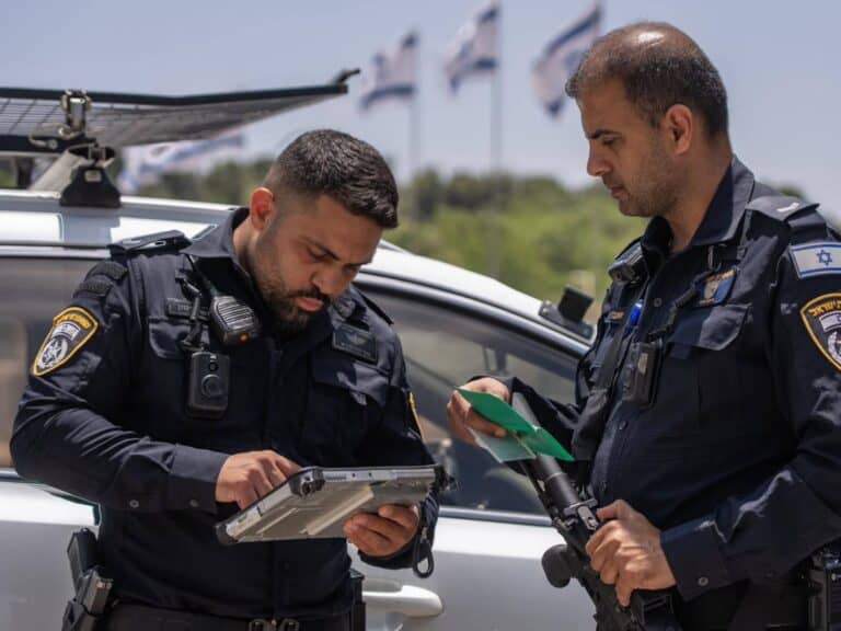 Jerusalem police officers operating advanced identification system during field operation sw