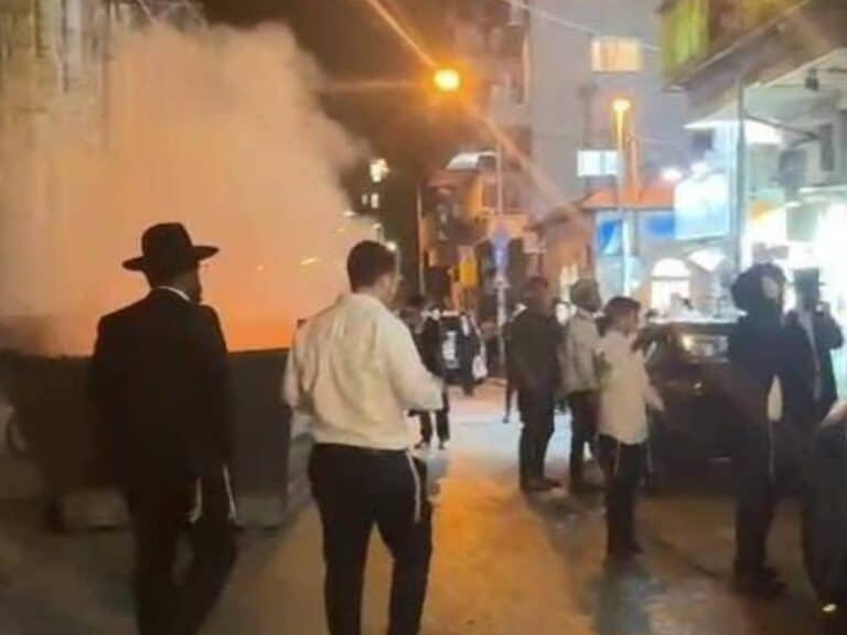 Burning garbage bins and clashes with police during an ultra-Orthodox protest against the military draft law in central Jerusalem ar