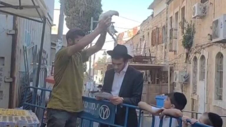 Lelaki memegang ayam dalam ritual kapparot di kawasan religius Baitulmaqdis