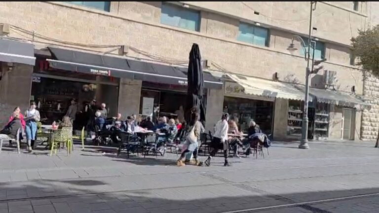 בתי קפה מלאים והולכי רגל ברחוב יפו בירושלים ביום של שמש חורפית נעימה