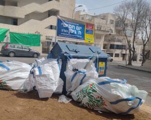 שקי גניזה ליד מיכל כחול ברחובות ירושלים לקראת פסח 2026