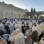 מתפללים בברכת הכהנים ברחבת הכותל המערבי בירושלים במהלך חג הפסח