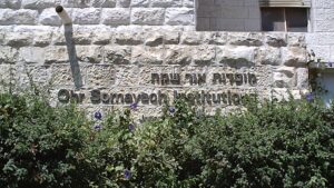 מבנה ישיבת אור שמח בירושלים עם שילוט באנגלית ובעברית על קיר אבן