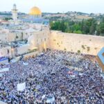 המונים ברחבת הכותל המערבי בירושלים במהלך אירוע חגיגי, כשברקע כיפת הסלע והעיר העתיקה