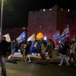 שוטרים ומשתתפים בצעדה סמוך לחומות העיר העתיקה בירושלים במהלך אירועי תשעה באב