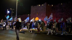 שוטרים ומשתתפים בצעדה סמוך לחומות העיר העתיקה בירושלים במהלך אירועי תשעה באב
