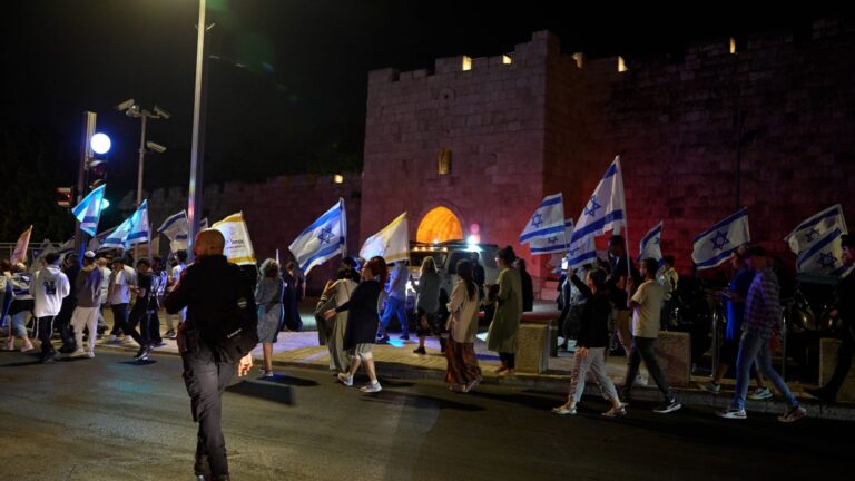 Police officers and march participants near the walls of Jerusalem’s Old City during Tisha B’Av events