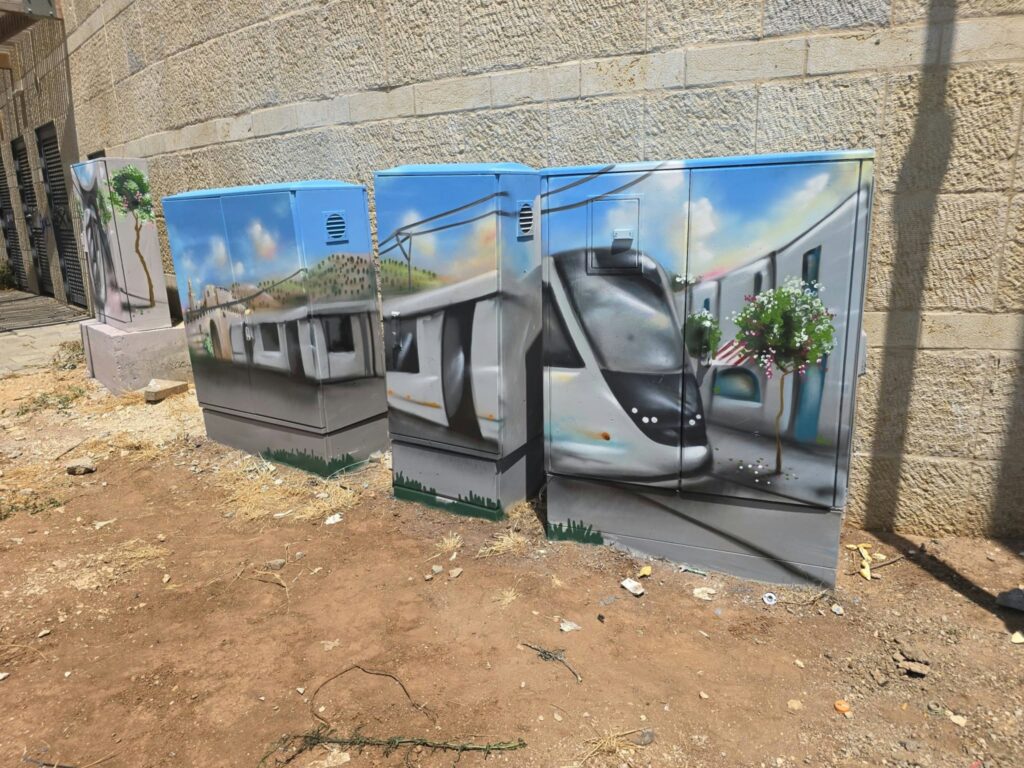 ארונות חשמל מעוטרים בציורי אמנות רחוב בירושלים, בהם ציור הרכבת הקלה ונופי העיר במסגרת פרויקט עירוני