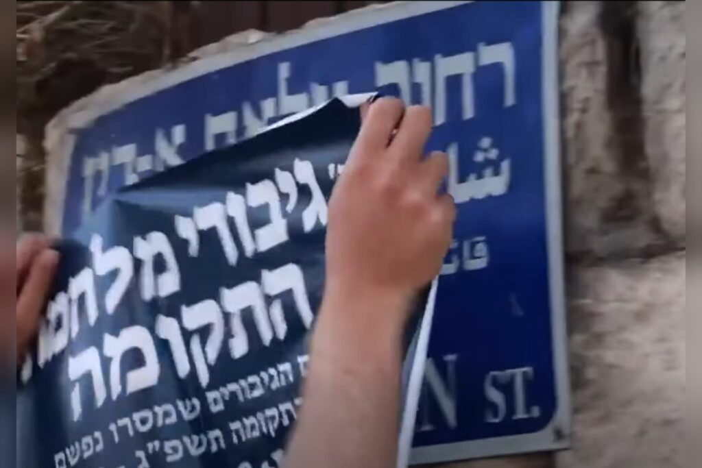 פעילי ימין מדביקים שלט עם השם גיבורי מלחמת התקומה על שלט רחוב צלאח א-דין במזרח ירושלים