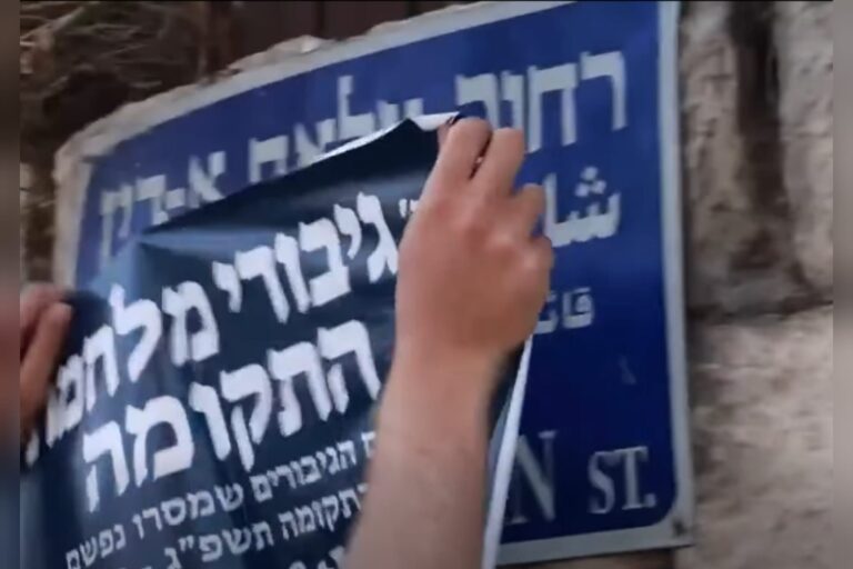 פעילי ימין מדביקים שלט עם השם גיבורי מלחמת התקומה על שלט רחוב צלאח א-דין במזרח ירושלים