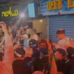 תומכי בנימין נתניהו מניפים ידיים וטלפונים במהלך ביקורו בשוק מחנה יהודה בירושלים לקראת הבחירות לכנסת