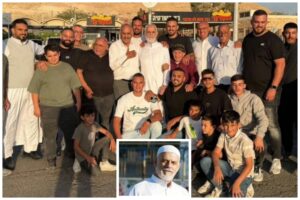 שיח' ג'מאל מוסטפא, האימאם מעיסאוויה במזרח ירושלים, בתצלום קבוצתי לאחר שחרורו מהכלא, לצד תמונת דיוקן שלו